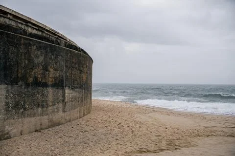 Waves breaking along sandy beach under cloudy sky in Santa Cruz Portugal Stock Photos