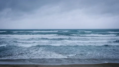 Waves breaking on a beach a dark stormy day 스톡 동영상 231670181