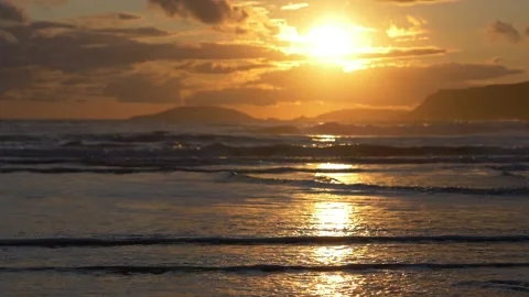 Waves breaking on beach during sunset Stock Footage 141533121