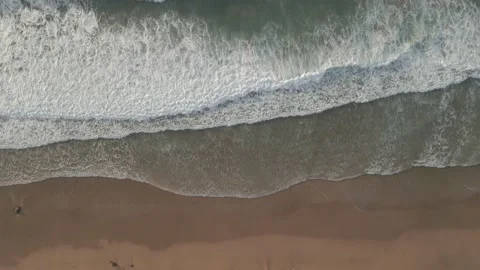 Waves breaking at the beach shore aerial overhead drone footage Stock Footage 147358083