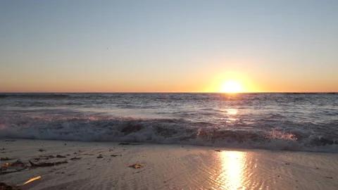 Waves breaking on beach at sunset. Slow motion dolly right. Stock Footage 161246328