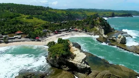 Waves breaking on Big rock at Klayar beach, East Java in Indonesia. Aerial Stock Footage 166038216