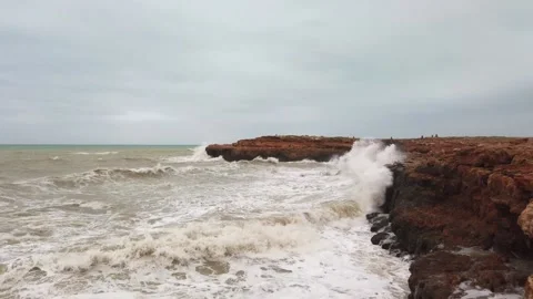 Waves breaking on the black rock 4k Stock Footage 133807362