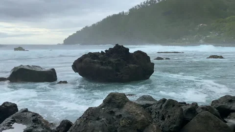 Waves breaking on black rocks in the bay of Manapany on Reunion Island Stock Footage 143723105