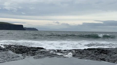 Waves Breaking With Cliffs in Background Stock Footage