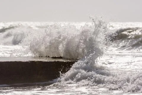 Waves breaking on the concrete pier Stock Photos