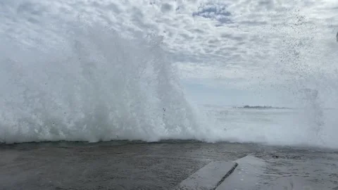 Waves breaking on concrete road barrier Stock Footage 282477342