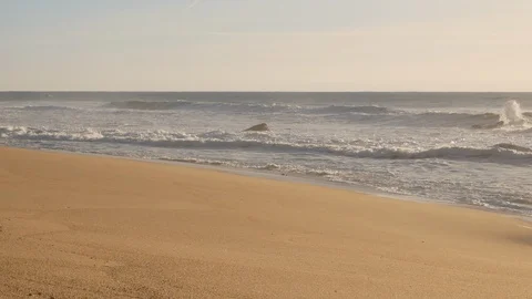 Waves breaking on an empty, misty, sandy beach in the morning. Slow slide left Video stock 103281372