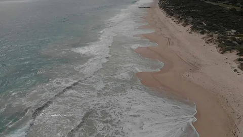 Waves breaking empty sandy beach aerial tracking footage Stock Footage 114556241