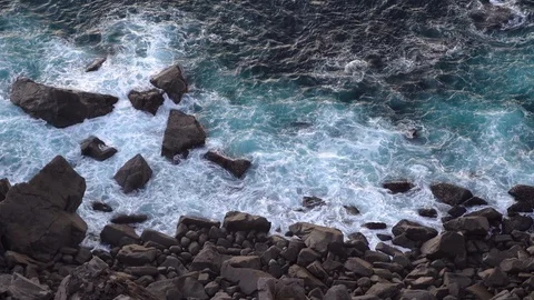 Waves breaking eroding dark basalt rocks near shore. Stock Footage 110760378