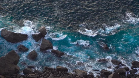 Waves breaking erosion eroding dark basalt rocks near shore. 動画素材 110761711