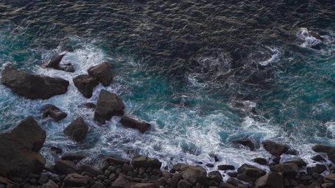 Waves breaking erosion eroding dark basalt rocks near shore. Stock Footage 110761716