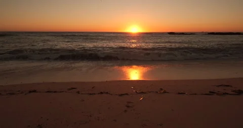 Waves breaking on golden beach in summer at sunset. Tilt up. 動画素材 161246396