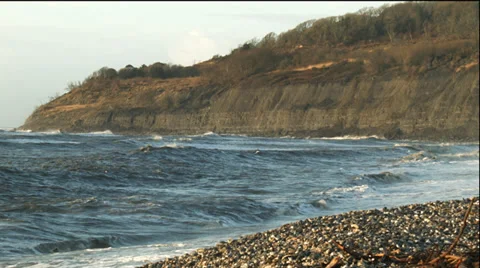Waves breaking at Lyme Regis with the cliffs of Monmouth Beach in the background Stock Footage 33920044