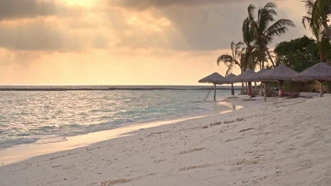 Waves breaking on a maldivian beach at sunset Stock Footage 125633993