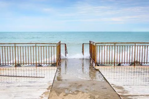 Waves breaking on the old pier. Stock Photos