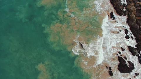 Waves breaking over coastal rocks aerial top down in California Stock-Footage 348046676