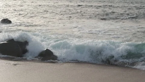Waves breaking over rocks on beach in slow motion Stock Footage 172484564