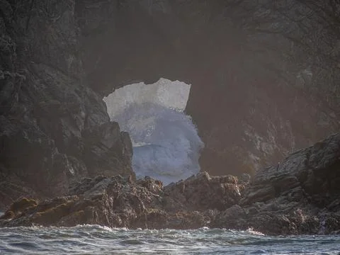 Waves breaking over the rocks Stock Photos