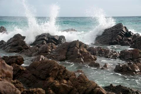 Waves breaking over rocks at Stokes Bay Stock Photos