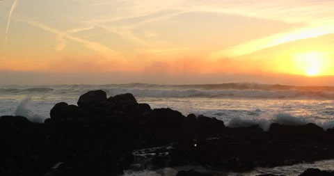 Waves breaking over rocks at sunset in Portugal in Winter. Video stock 166815351