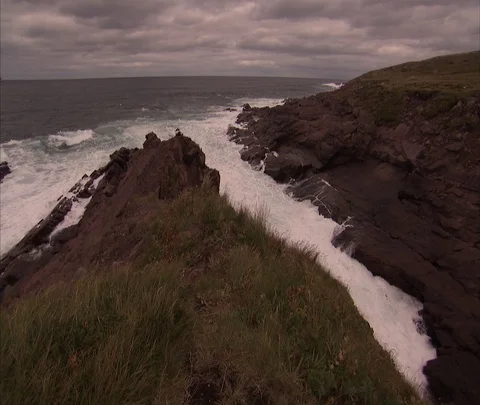 Waves breaking over rocky coast Stock Footage 86698051