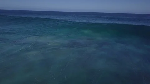 Waves breaking over shallow reefs shot from the front with a drone Stock Footage 120860158