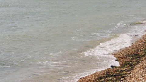 Waves breaking onto a pebbled beach 库存影片 75078654