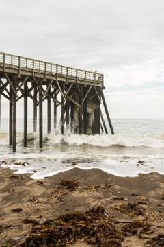 Waves breaking on the poles under the pier of San Simeon, California, USA Stock Photos