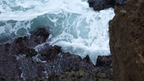 Waves breaking on a rock with foam and mist Stock Footage 106359541