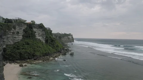 Waves breaking on the rocks on Bali Island Beach 4K Drone flight Stock Footage 119318680