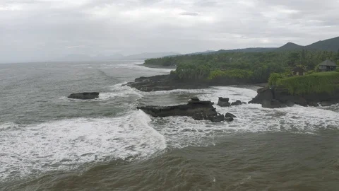 Waves breaking on the rocks on Bali Island Beach 4K Drone flight Stock Footage 119320295