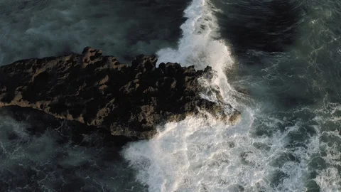 Waves breaking on the rocks Batu Balong beach Bali Island 4K Drone flight Stock Footage 119290811
