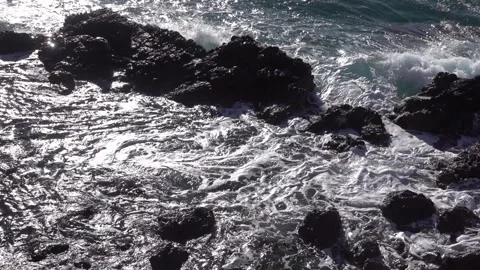 Waves breaking on rocks in bright sunlight Video stock 332609610