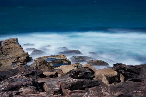 Waves breaking on the rocks of Manly Beach. Stock Photos