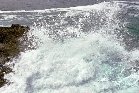 Waves breaking on the rocks at the shore of the beach Stock Photos