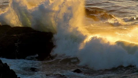 Waves breaking onto rocks at sunrise. Video stock 88381361