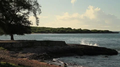 Waves breaking in sand and stone structure on beach Video stock 8763267