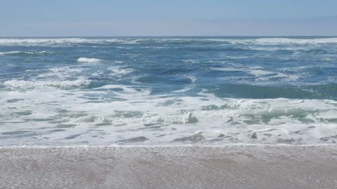 Waves breaking on sand at beach, slider shot moving left to right. Видео 104441991