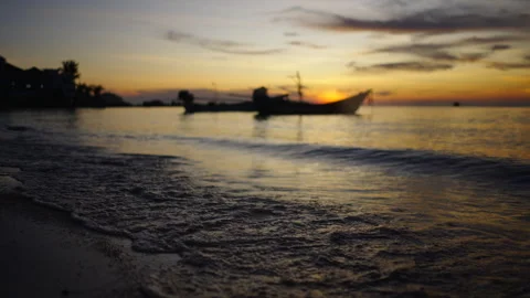 Waves breaking on the sand of a Thai beach under a stunning sunset Stock Footage 246594326