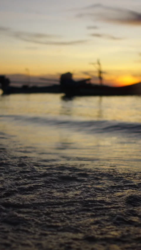 Waves breaking on the sand of a Thai beach under a stunning sunset Video stock 265470250