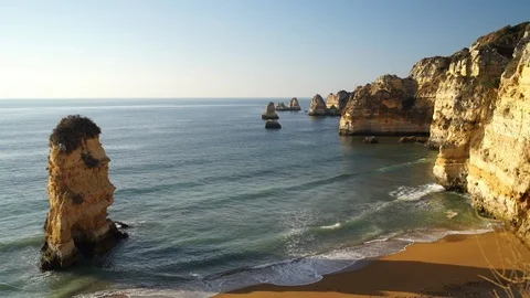 Waves breaking on sandy ocean beach Praia Dona Ana with famous beautiful coastal Stock Footage 103444053