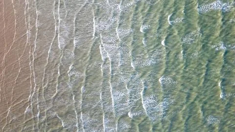 Waves breaking on the shore from above Stock Photos