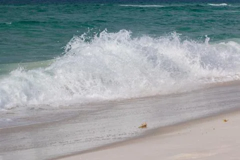 Waves breaking on the shore at the beach. Stock Photos