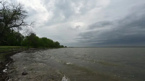 Waves breaking on the shore of a large lake on a stormy summer afternoon Stock Footage 341835230