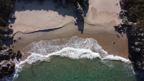 Waves breaking on the shore from the view of a drone Stock Footage 239225867