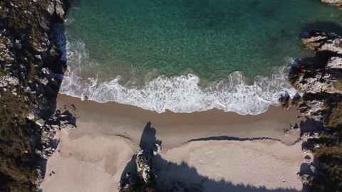 Waves breaking on the shore from the view of a drone Stock Footage 239225949
