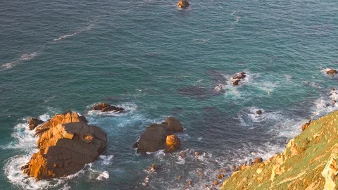 Waves breaking in slow motion against two huge boulders in the water Stock Footage 110760045