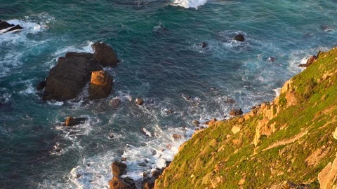 Waves breaking in slow motion against two huge boulders in the water Stock Footage 110761471