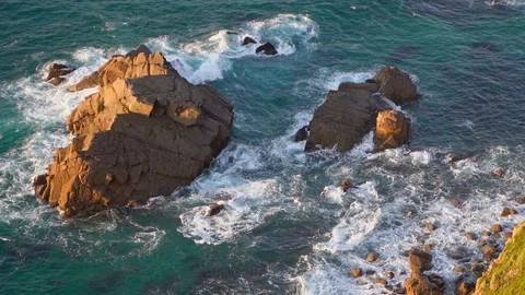 Waves breaking in slow motion against two huge boulders in the water 動画素材 110761473